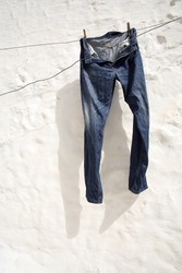 Jeans hung on a white wall.