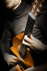 Acoustic guitar guitarist playing details. Musical instrument with musician hands. Focus is on the hand with instrument