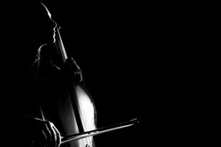 Cello classical music cellist player. Cellist with musical instrument in darkness