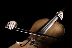 Cello player. Cellist hands playing cello with bow orchestra musical instrument closeup. Violoncello
