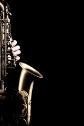 Saxophone player. Saxophonist sax jazz orchestra instrument hands isolated on black background close up
