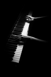 Piano player. Pianist hands playing grand piano keys. Music instrument keyboard isolated on black background