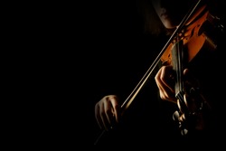 Violin player hands. Violinist playing violin isolated on black. Close up of musical instruments