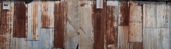Background made of rusted iron sheet metal and corrugated iron which are fastened together. Widescreen image