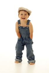 Adorable happy little boy in overalls