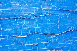 Cracked blue paint on a wooden surface, as a background