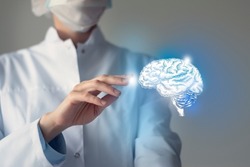Female doctor touches virtual Brain in hand. Blurred photo, handrawn human organ, highlighted blue as symbol of recovery. Healthcare hospital service concept stock photo