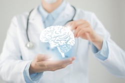 Female doctor holding virtual volumetric drawing of  Brain in hand. Handrawn human organ, copy space on right side, raw photo colors. Healthcare hospital service concept stock photo