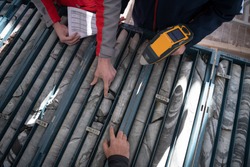 geological gold core samples with team of mining  workers measuring drilled rock top view