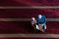 father and son reading holly book quran together islamic education concept