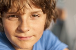 European school-age boy with brown eyes looking directly at the camera, close-up