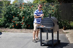 Man starting a grill on a sunny summer day