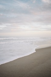 Gentle waves crashing on Carolina Beach with pink and blue sunset