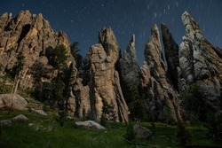 Massive spires of the Black Hills illuminated at night by a dron