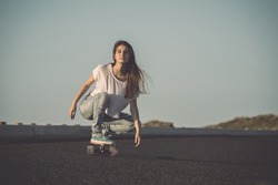 Young woman making downhill with a skateboard
