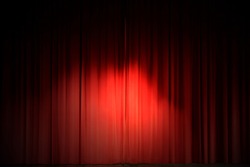 Center stage spotlight against a red velvet curtain
