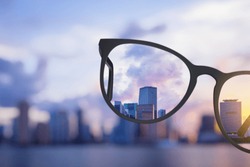 Modern bright city view through eyeglasses. Blurry background. Vision concept