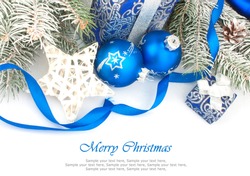 Christmas accessories in blue & fir tree branch on white