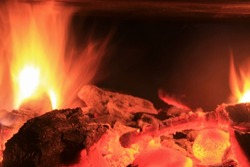Flame of burning firewood in the fireplace. Warmth and comfort