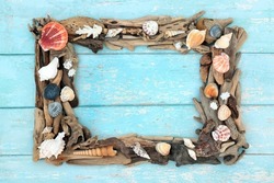 Driftwood and sea shell abstract seaside art border on rustic blue background. Treasure of the sea nature sculpture. Natural rectangular composition. Top view, flat lay.