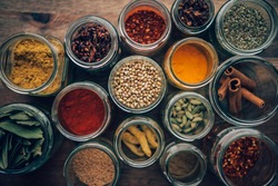 Assortment of colorful spices in glass jars.