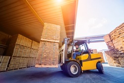 Forklift loader load lumber into a dry kiln. Wood drying in containers. Industrial concept