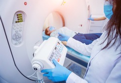Radiologist with a female patient in the room of computed tomography