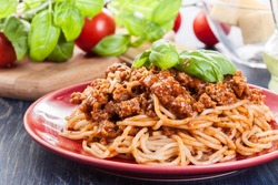 Spaghetti bolognese with cheese and basil on a plate