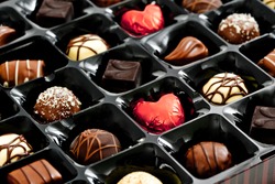 chocolates in a box, with red love heart shaped chocolate