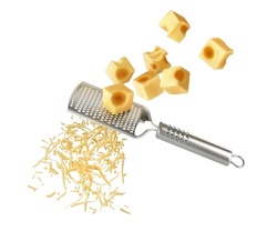 Pieces of cheese falling on a grater with cheese shavings on a white background