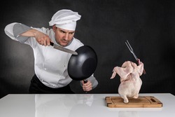 Chef fighting with knife and pan. Raw chicken attack