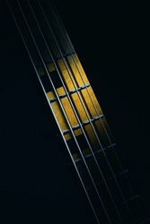 Closeup view of neck of five strings bass guitar, highlighted shapes.