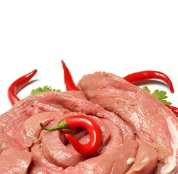 Raw cuts of beef with hot red peppers on a white background.       