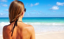 Back of beautiful girl in bikini  on tropical beach