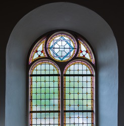 Colorful leaded glass window in a Dutch church from close.