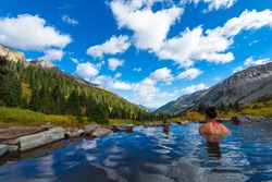 Woman relaxing in hot spring pool Conundrum Hot Springs near Aspen Colorado