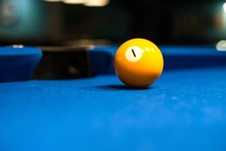 yellow billiard ball number one is on the blue table at the pocket
