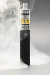 Electronic cigarette against background full of smoke