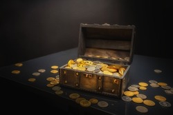 Heap of coins in small wooden chest closeup photo