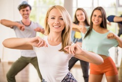 Young dancing people in gym during exercise dancer workout training with happy fresh energy.