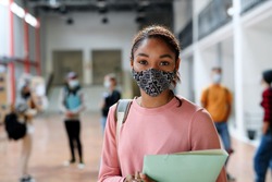 African-american student with face mask back at college or university, coronavirus concept.