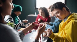 Group of people playing cards and board games in community center, inclusivity of disabled person.