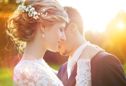 Young wedding couple enjoying romantic moments outside on a summer meadow