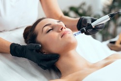 Shot of cosmetologist making mesotherapy injection with dermapen on face for rejuvenation on the spa center.