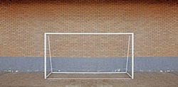 A futsal soccer goal post against a brickwall. 