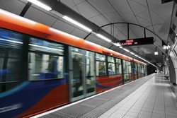 A subway train in motion arriving at a London underground train station.