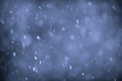 Background of snow flurry falling at night with motion blur