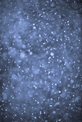 Background of snow flurry falling at night with motion blur