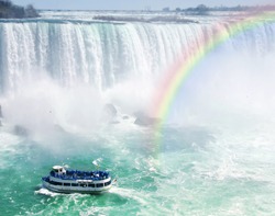 Spectacular rainbow near tourist boat at Niagara Falls
