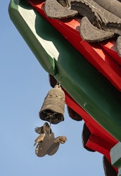 tiny birds standing on oriental temple bell
